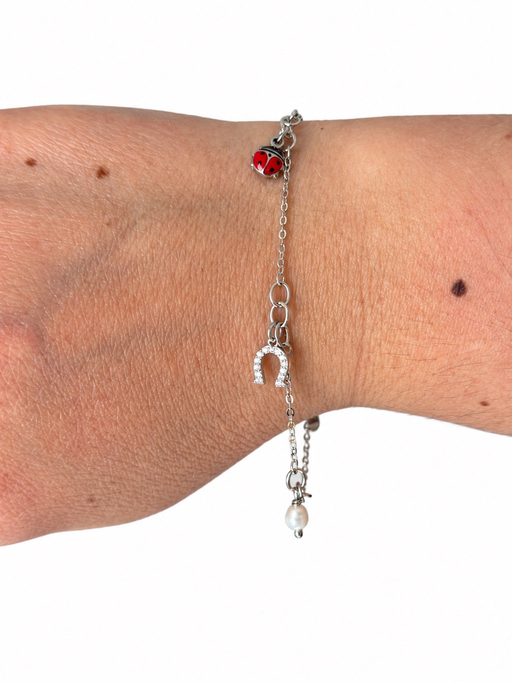Bracciale catena con ciondoli portafortuna, perla naturale, ferro di cavallo e coccinella in Argento 925 indossato