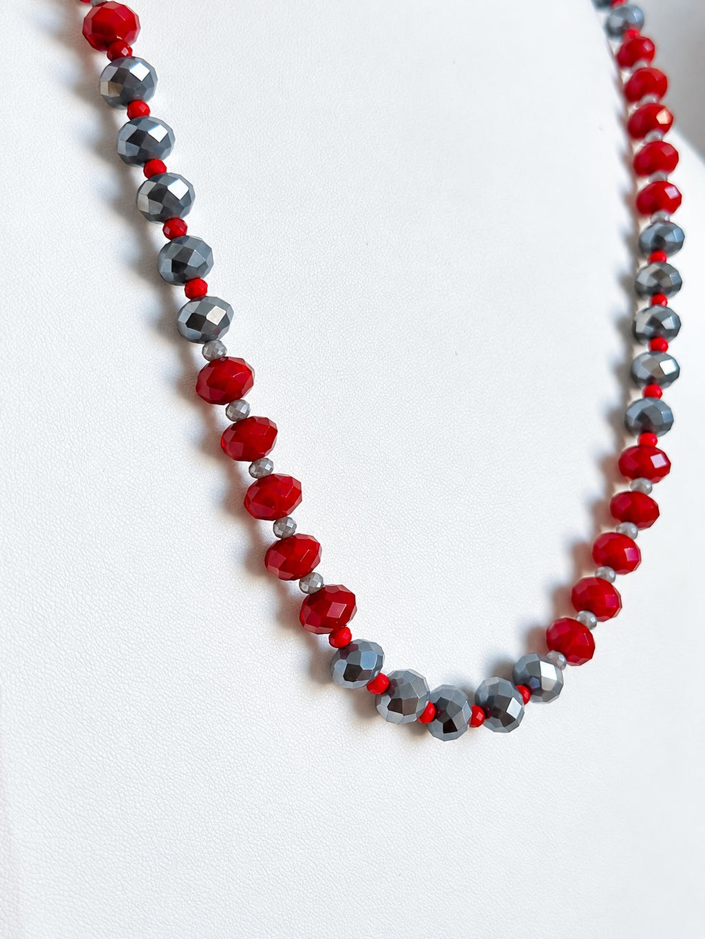 Dettaglio delle perle sfaccettate rosse e grigie