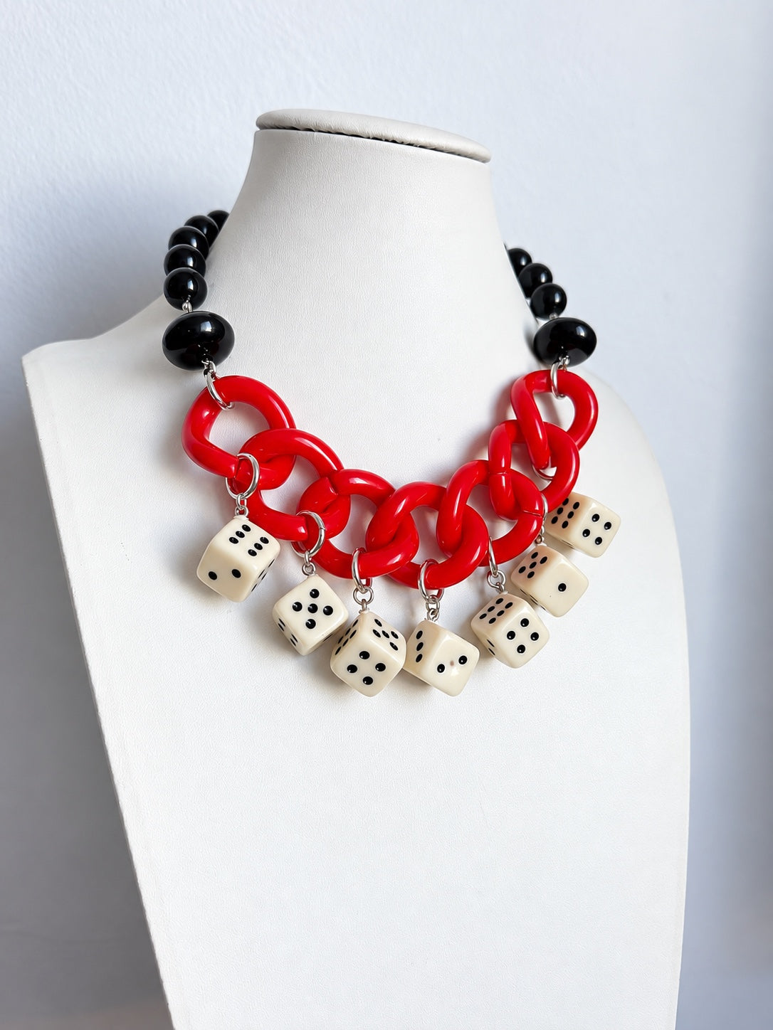 Collana artigianale con sfere nere, catena rossa e dadi, vista frontale
